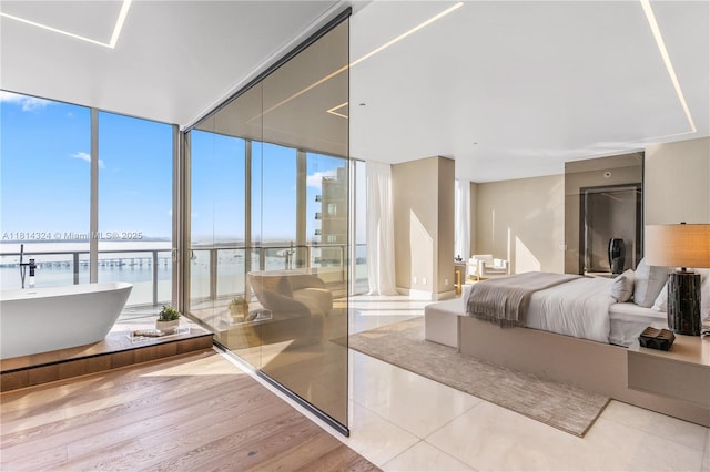 1300 Brickell Bay Dr Unit 4400, Miami, FL 33131 - bedroom with expansive windows, a water view, and wood finished floors