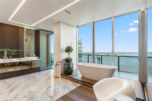 1300 Brickell Bay Dr Unit 4400, Miami, FL 33131 - full bath with vanity, marble tiled flooring, a water view, a freestanding bath, and expansive windows