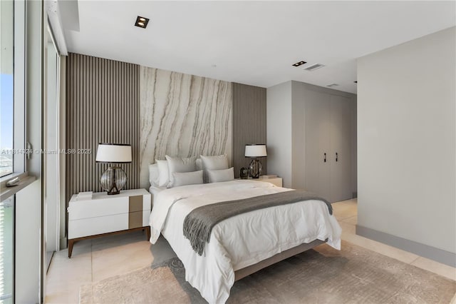 1300 Brickell Bay Dr Unit 4400, Miami, FL 33131 - bedroom featuring an accent wall, wallpapered walls, light tile patterned floors, and a closet