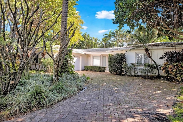 345 Harbor Ln, Key Biscayne, FL 33149 - ranch-style house featuring an attached garage, stucco siding, and driveway