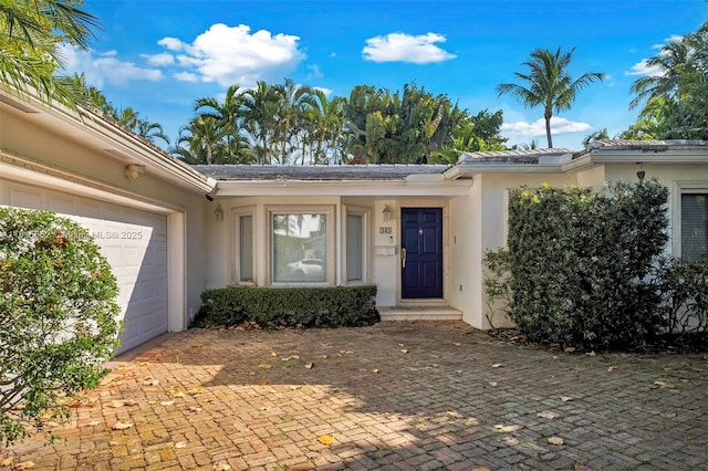 345 Harbor Ln, Key Biscayne, FL 33149 - property entrance with stucco siding, a garage, and driveway