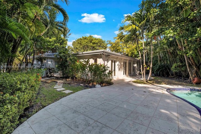 345 Harbor Ln, Key Biscayne, FL 33149 - view of front facade featuring a patio, an outdoor pool, and stucco siding