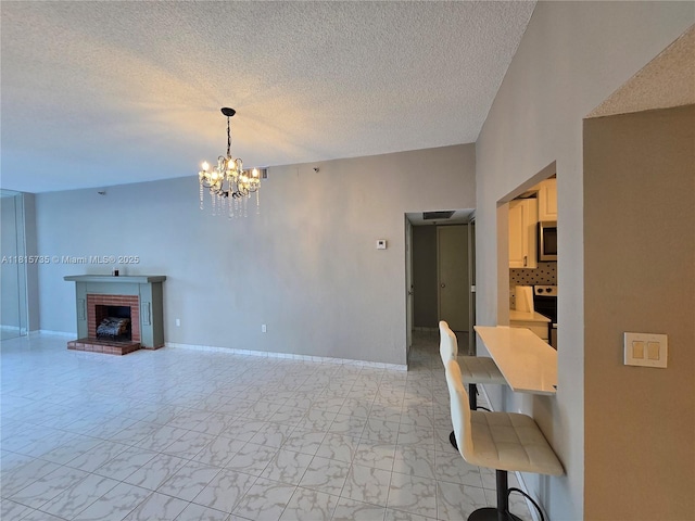 20505 E Country Club Dr Unit 138, Aventura, FL 33180 - unfurnished living room with a chandelier, a textured ceiling, a brick fireplace, baseboards, and light marble finish flooring
