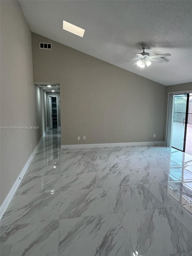 5416 Eagle Lake Dr Unit 4, Palm Beach Gardens, FL 33418 - empty room featuring light marble finish flooring, ceiling fan, vaulted ceiling, and a textured ceiling