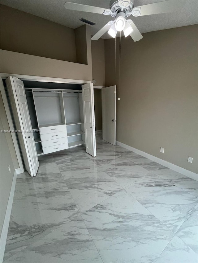 5416 Eagle Lake Dr Unit 4, Palm Beach Gardens, FL 33418 - unfurnished bedroom featuring light marble finish floors, a closet, a ceiling fan, and a textured ceiling