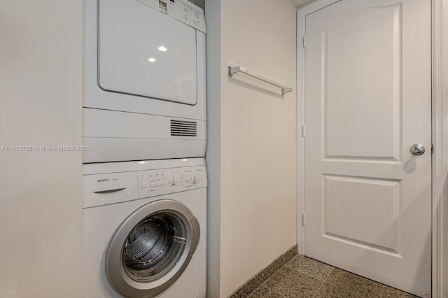 5600 Collins Ave Unit 10E, Miami Beach, FL 33140 - laundry room with estacked washer and dryer and baseboards