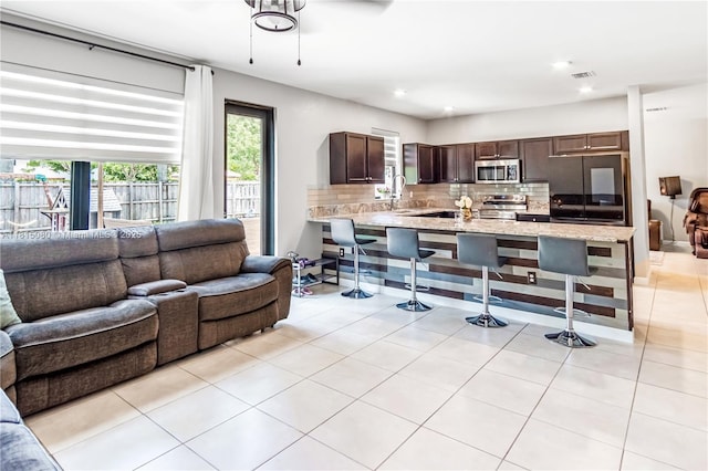 724 SE 37th Ave, Homestead, FL 33033 - kitchen with appliances with stainless steel finishes, open floor plan, backsplash, a peninsula, and dark brown cabinets