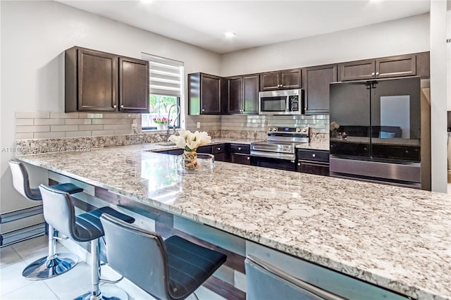 724 SE 37th Ave, Homestead, FL 33033 - kitchen featuring stainless steel appliances, dark brown cabinets, light stone countertops, backsplash, and recessed lighting