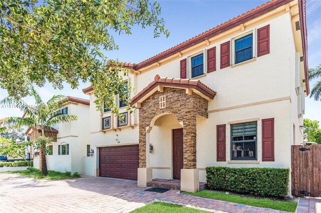 724 SE 37th Ave, Homestead, FL 33033 - mediterranean / spanish house featuring stucco siding, a garage, stone siding, decorative driveway, and a tile roof