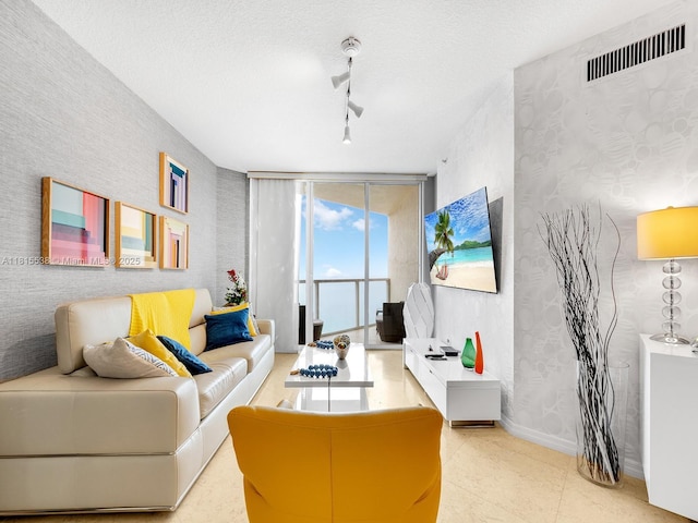 16699 Collins Ave Unit 2906, Sunny Isles Beach, FL 33160 - tiled living room with wallpapered walls, baseboards, track lighting, and a textured ceiling