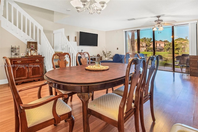 10630 NW 14th St Unit 115, Plantation, FL 33322 - dining area with stairs, light wood finished floors, a chandelier, and ceiling fan