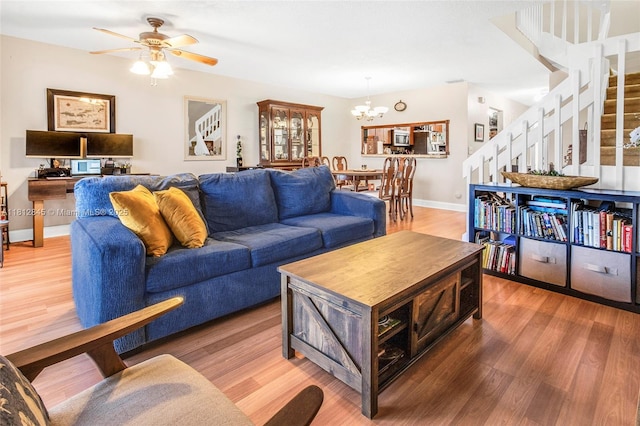 10630 NW 14th St Unit 115, Plantation, FL 33322 - living room with stairway, light wood-style flooring, ceiling fan, baseboards, and a chandelier