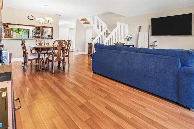10630 NW 14th St Unit 115, Plantation, FL 33322 - living room with light wood-type flooring, stairway, and a chandelier