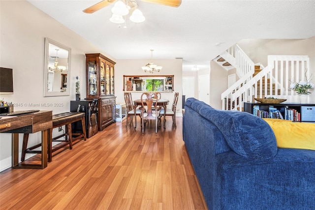 10630 NW 14th St Unit 115, Plantation, FL 33322 - living room featuring light wood finished floors, a chandelier, stairs, and a ceiling fan