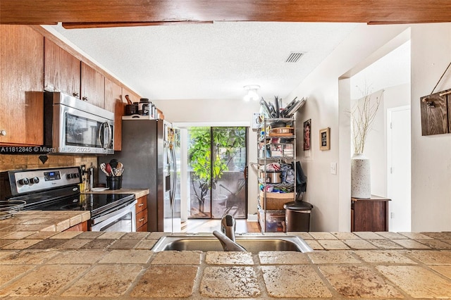 10630 NW 14th St Unit 115, Plantation, FL 33322 - kitchen with appliances with stainless steel finishes, a sink, and brown cabinets