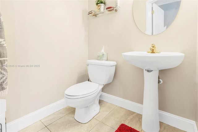 10630 NW 14th St Unit 115, Plantation, FL 33322 - half bathroom featuring toilet, tile patterned flooring, baseboards, and a sink