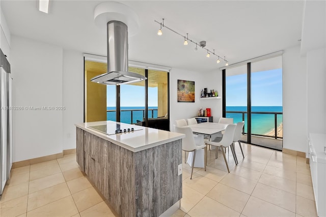 16275 Collins Ave Unit 2101, Sunny Isles Beach, FL 33160 - kitchen with floor to ceiling windows, island range hood, black electric cooktop, modern cabinets, and a water view