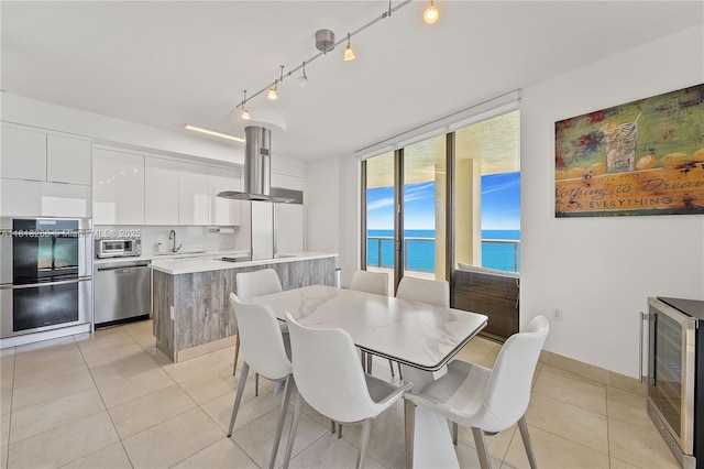 16275 Collins Ave Unit 2101, Sunny Isles Beach, FL 33160 - dining space with wine cooler, light tile patterned flooring, and a water view