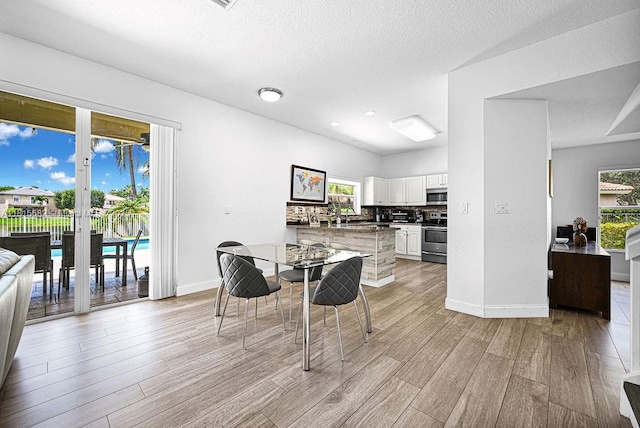 4007 Turquoise Trl, Weston, FL 33331 - kitchen featuring stove, stainless steel microwave, light wood finished floors, plenty of natural light, and a textured ceiling