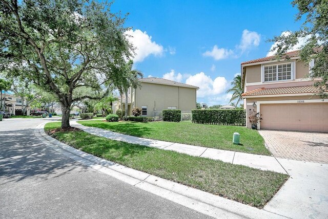 4007 Turquoise Trl, Weston, FL 33331 - view of home's exterior with stucco siding, decorative driveway, an attached garage, a lawn, and a tile roof