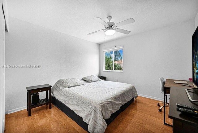 4007 Turquoise Trl, Weston, FL 33331 - bedroom featuring baseboards, wood finished floors, a ceiling fan, a desk, and a textured ceiling