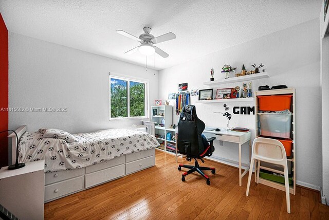 4007 Turquoise Trl, Weston, FL 33331 - bedroom with wood-type flooring, a textured ceiling, a desk, and ceiling fan