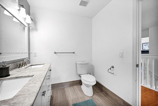 4007 Turquoise Trl, Weston, FL 33331 - bathroom with toilet, double vanity, baseboards, and wood finished floors
