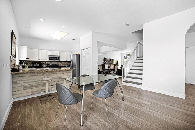 4007 Turquoise Trl, Weston, FL 33331 - dining area featuring wood finished floors, arched walkways, stairs, baseboards, and recessed lighting