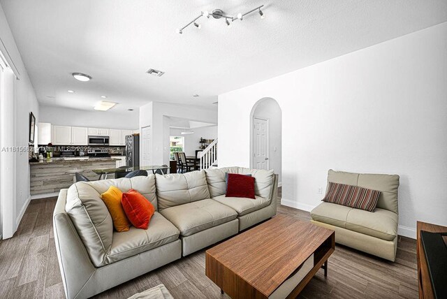 4007 Turquoise Trl, Weston, FL 33331 - living room featuring baseboards, arched walkways, stairway, and wood finished floors