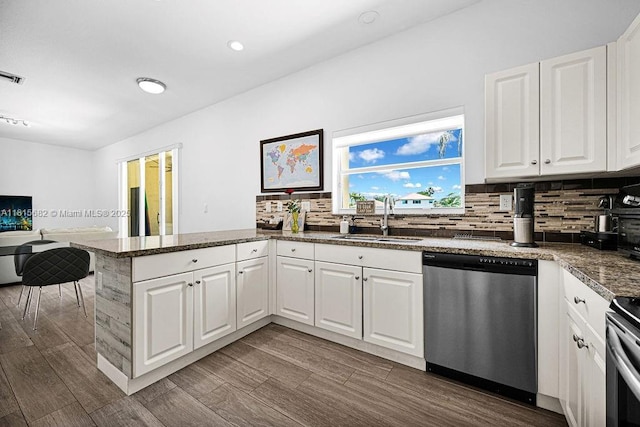 4007 Turquoise Trl, Weston, FL 33331 - kitchen with stainless steel appliances, a sink, a peninsula, decorative backsplash, and white cabinets