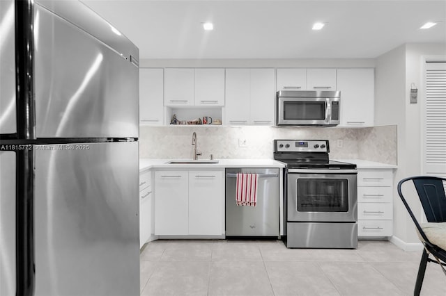 3301 S Palm Aire Dr Unit 106, Pompano Beach, FL 33069 - kitchen with stainless steel appliances, a sink, light countertops, decorative backsplash, and white cabinets