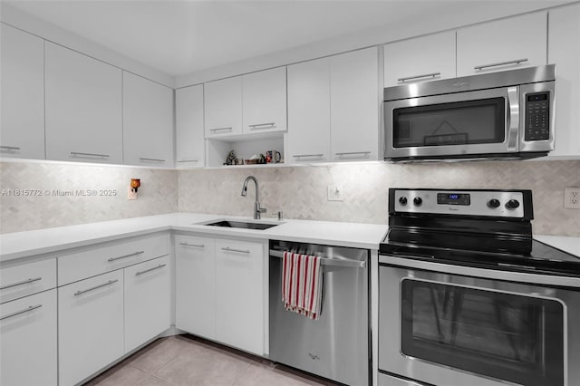 3301 S Palm Aire Dr Unit 106, Pompano Beach, FL 33069 - kitchen featuring appliances with stainless steel finishes, a sink, light countertops, and white cabinets