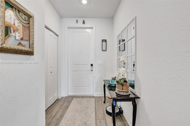 680 SE Lake Falls St, Port St Lucie, FL 34984 - doorway with wood finished floors, a textured wall, and baseboards