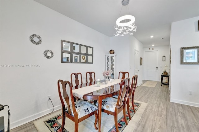 680 SE Lake Falls St, Port St Lucie, FL 34984 - dining room with light wood finished floors, a chandelier, baseboards, and recessed lighting