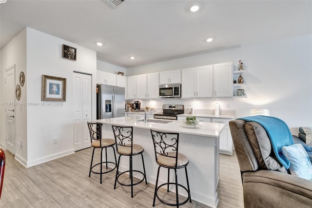 680 SE Lake Falls St, Port St Lucie, FL 34984 - kitchen with appliances with stainless steel finishes, a sink, a breakfast bar, white cabinets, and light countertops