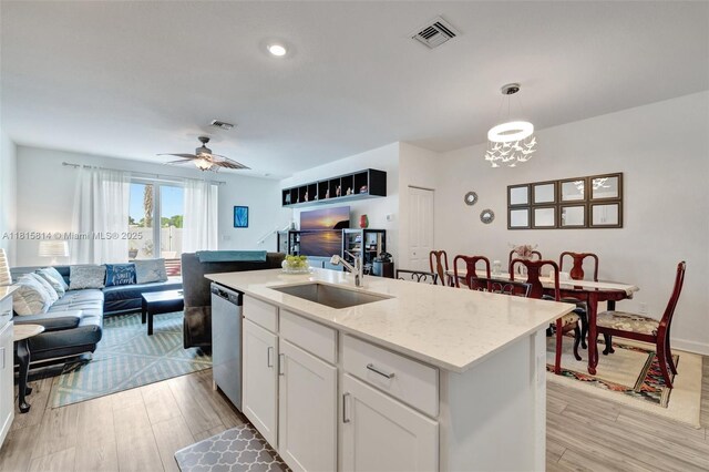 680 SE Lake Falls St, Port St Lucie, FL 34984 - kitchen featuring dishwasher, open floor plan, a sink, and white cabinets