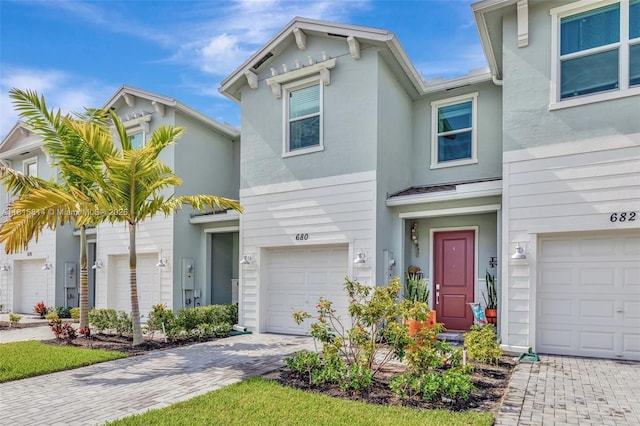 680 SE Lake Falls St, Port St Lucie, FL 34984 - multi unit property with decorative driveway, an attached garage, and stucco siding
