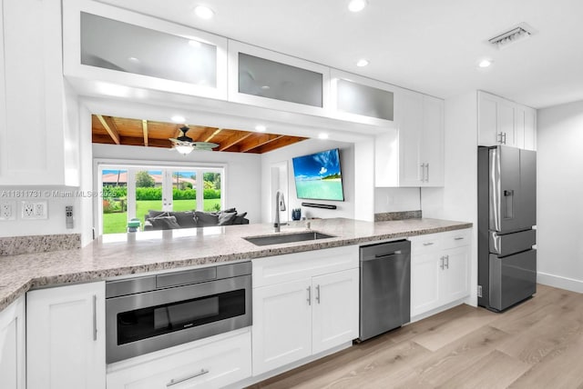 13711 SW 29th St, Davie, FL 33330 - kitchen with appliances with stainless steel finishes, a sink, light wood-type flooring, white cabinetry, and light stone counters