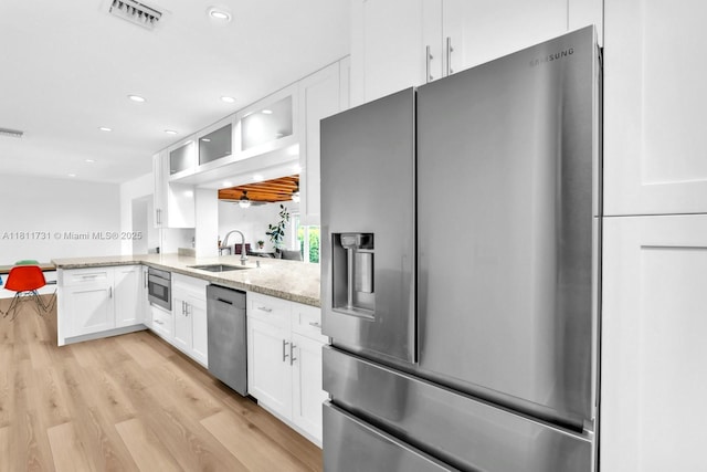 13711 SW 29th St, Davie, FL 33330 - kitchen with appliances with stainless steel finishes, light stone countertops, glass insert cabinets, white cabinetry, and light wood-type flooring