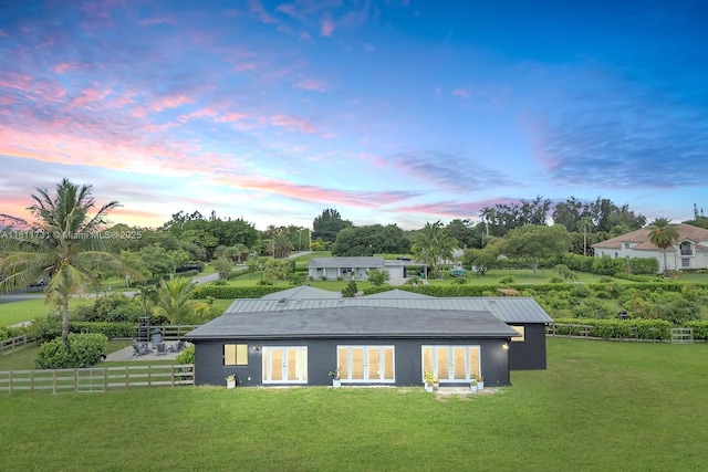 13711 SW 29th St, Davie, FL 33330 - back of property at dusk with french doors, view of scattered trees, and stucco siding
