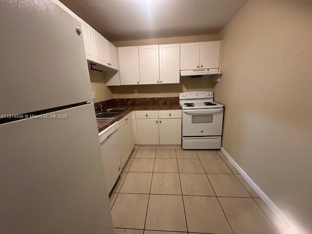 9001 SW 77th Ave Unit C705, Miami, FL 33156 - kitchen featuring white appliances, under cabinet range hood, dark countertops, and white cabinetry
