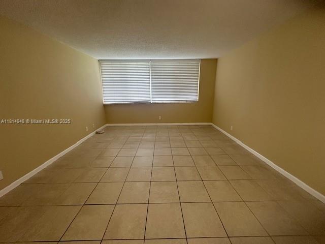 9001 SW 77th Ave Unit C705, Miami, FL 33156 - spare room with light tile patterned flooring and baseboards