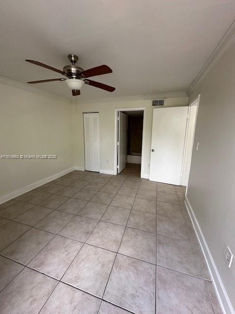 6955 NW 186th St Unit F301, Hialeah, FL 33015 - empty room featuring a ceiling fan, crown molding, light tile patterned floors, and baseboards