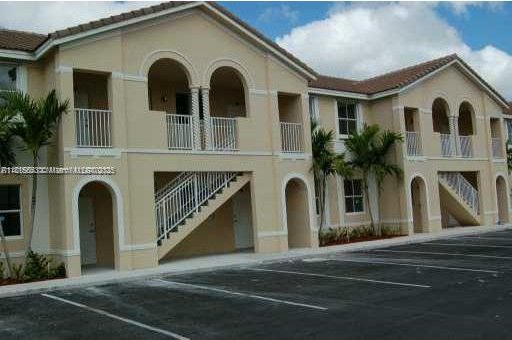 1666 SE 27th Ct Unit 205, Homestead, FL 33035 - view of building exterior with stairway and uncovered parking