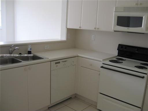 1666 SE 27th Ct Unit 205, Homestead, FL 33035 - kitchen featuring white appliances, a sink, white cabinetry, and light countertops