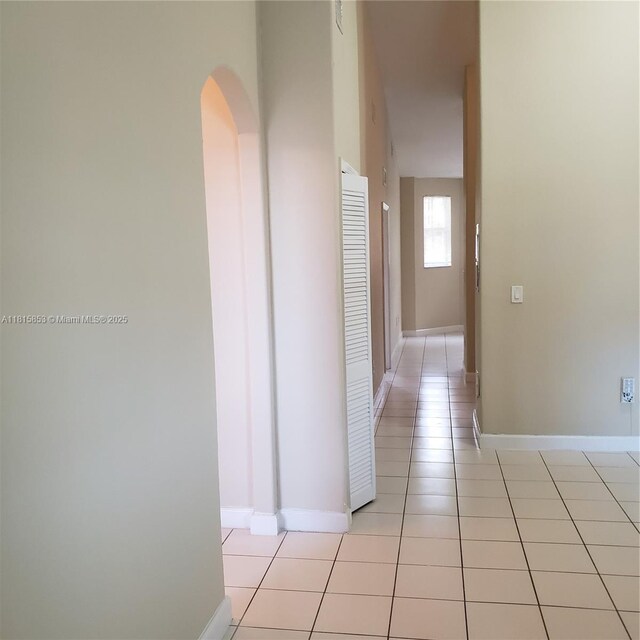 1666 SE 27th Ct Unit 205, Homestead, FL 33035 - hall with arched walkways, light tile patterned floors, and baseboards