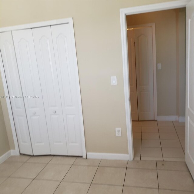 1666 SE 27th Ct Unit 205, Homestead, FL 33035 - unfurnished bedroom with light tile patterned floors, baseboards, and a closet