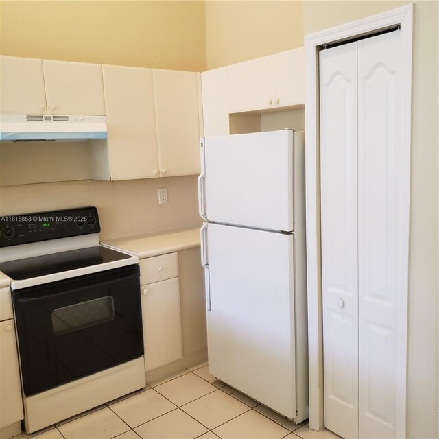 1666 SE 27th Ct Unit 205, Homestead, FL 33035 - kitchen featuring range with electric cooktop, under cabinet range hood, freestanding refrigerator, light countertops, and white cabinets