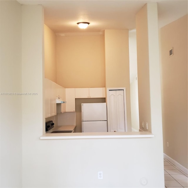 1666 SE 27th Ct Unit 205, Homestead, FL 33035 - kitchen featuring freestanding refrigerator, under cabinet range hood, range, light countertops, and a peninsula