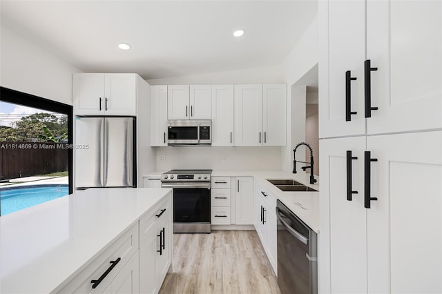 3105 SW 16th St, Fort Lauderdale, FL 33312 - kitchen featuring stainless steel appliances, a sink, white cabinetry, light countertops, and light wood-type flooring